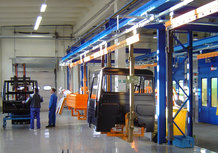 Overhead monorail system with painting cabin for the transport of components for the utility vehicle manufacturing